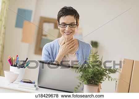 Woman using laptop in home office View Large Photo Image Stock Photo - Woman using laptop in home office. Fotosearch