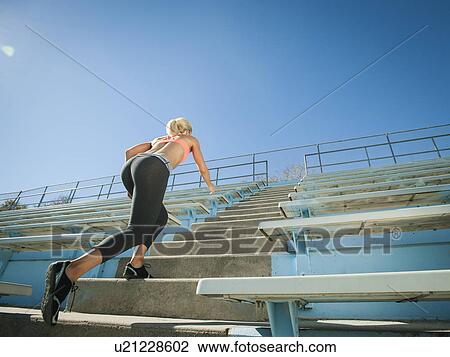 Stock Image - Woman walking up steps. Fotosearch