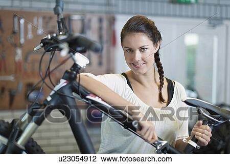 Woman with bicycle in workshop View Large Photo Image Stock Image - Woman with bicycle in workshop. Fotosearch