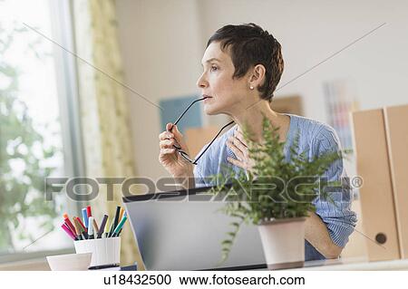 Stock Image - Woman working in home office. Fotosearch