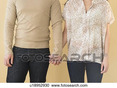 Stock Image - Young couple holding hands. Fotosearch