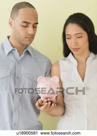 Young couple holding piggy bank View Large Photo Image Stock Image - Young couple holding piggy bank. Fotosearch