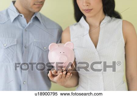Young couple holding piggy bank View Large Photo Image Stock Photography - Young couple holding piggy bank. Fotosearch