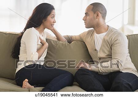 Young couple sitting on couch View Large Photo Image Stock Image - Young couple sitting on couch. Fotosearch