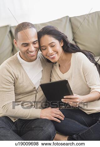 Young couple using digital tablets View Large Photo Image Stock Photo - Young couple using digital tablets. Fotosearch