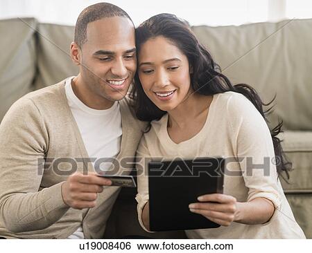 Young couple using digital tablets View Large Photo Image Stock Photograph - Young couple using digital tablets. Fotosearch