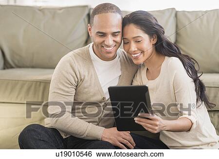 Young couple using digital tablets View Large Photo Image Stock Photograph - Young couple using digital tablets. Fotosearch