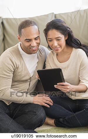 Young couple using digital tablets View Large Photo Image Stock Photography - Young couple using digital tablets. Fotosearch