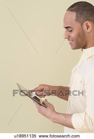 Young man using digital tablet View Large Photo Image Stock Photography - Young man using digital tablet. Fotosearch