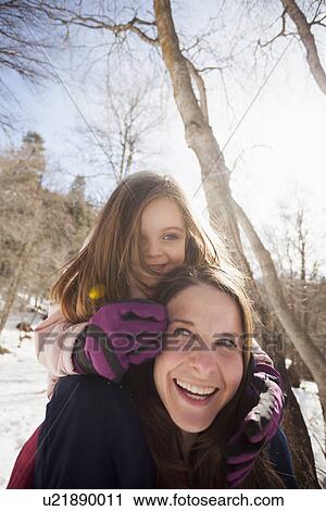 Stock Image - Young woman carrying her daughter (2-3) on shoulders. Fotosearch