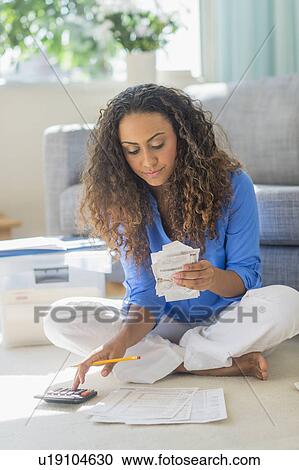 Stock Image - Young woman dealing with home finance. Fotosearch