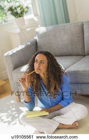 Stock Image - Young woman dealing with home finance. Fotosearch