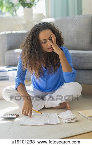 Stock Photo - Young woman dealing with home finance. Fotosearch