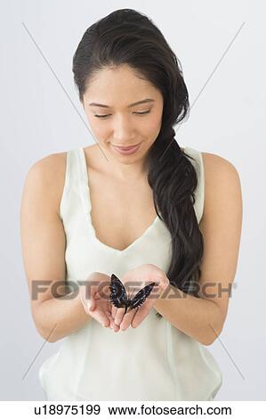 Young woman holding butterfly View Large Photo Image Stock Photo - Young woman holding butterfly. Fotosearch