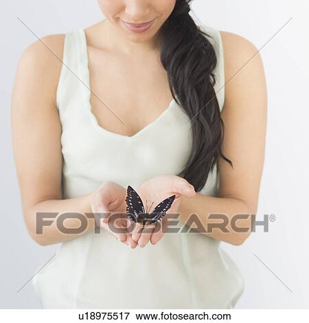 Young woman holding butterfly View Large Photo Image Stock Photo - Young woman holding butterfly. Fotosearch