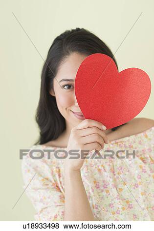 Young woman holding red paper heart View Large Photo Image Stock Photo - Young woman holding red paper heart. Fotosearch