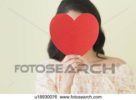 Stock Photograph - Young woman holding red paper heart. Fotosearch