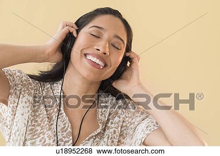 Young woman listening to music View Large Photo Image Stock Photo - Young woman listening to music. Fotosearch