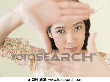 Stock Photography - Young woman looking through hand frame. Fotosearch