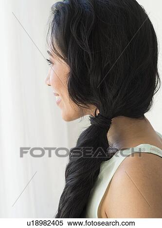 Stock Photography - Young woman looking through window. Fotosearch