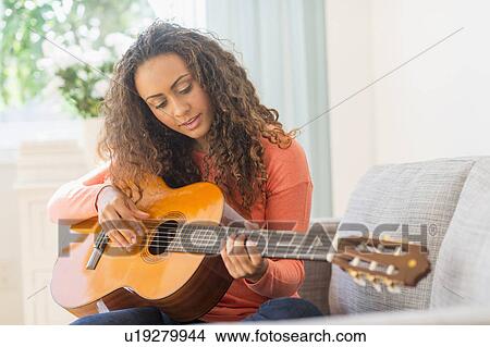 Picture - Young woman playing guitar. Fotosearch
