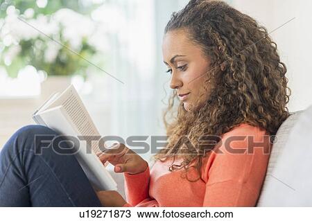 Young woman reading book at home View Large Photo Image Stock Image - Young woman reading book at home. Fotosearch