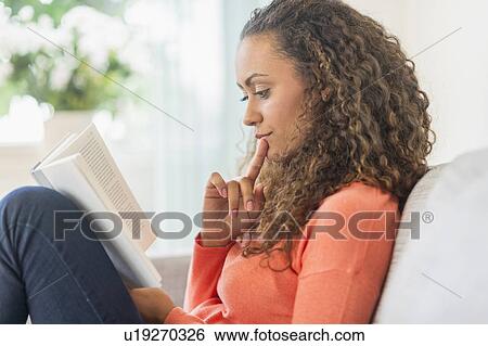 Young woman reading book at home View Large Photo Image Stock Photograph - Young woman reading book at home. Fotosearch