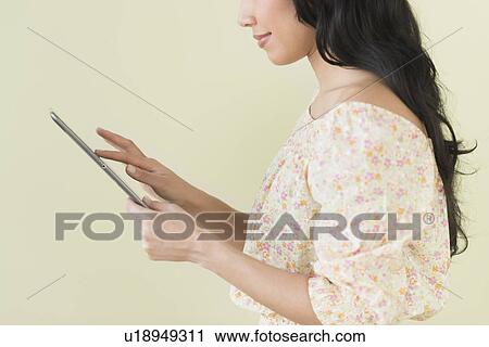 Stock Image - Young woman using digital tablet. Fotosearch