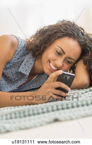Stock Image - Young woman using smartphone. Fotosearch