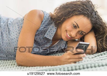 Young woman using smartphone View Large Photo Image Stock Photo - Young woman using smartphone. Fotosearch