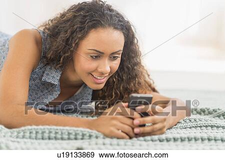 Young woman using smartphone View Large Photo Image Stock Photo - Young woman using smartphone. Fotosearch