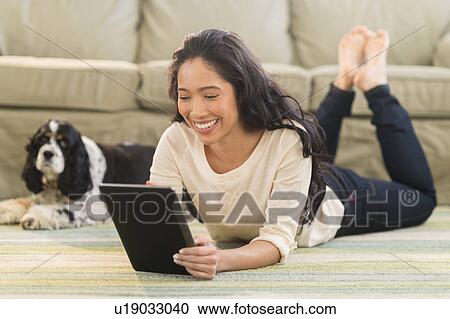 Young woman with dog in livingroom View Large Photo Image Stock Image - Young woman with dog in livingroom. Fotosearch