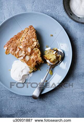 Stock Photo - Apple pie with almond flakes and creme fraiche. Fotosearch
