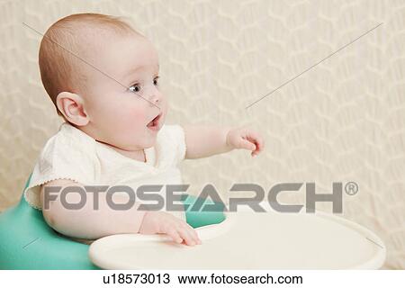 Stock Image - Baby girl in high chair. Fotosearch