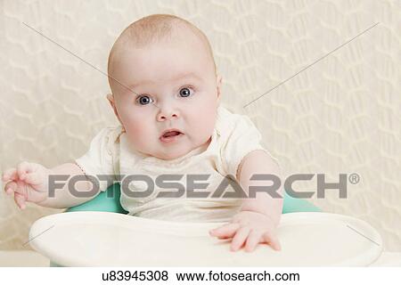 Stock Photo - Baby girl in high chair. Fotosearch