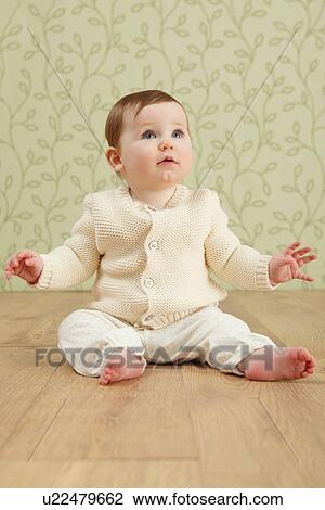 Stock Image - Baby girl in sitting on floor. Fotosearch