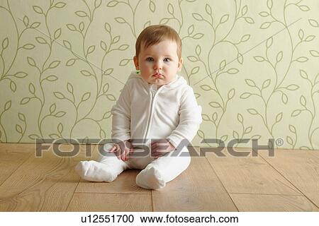 Stock Image - Baby girl sitting on floor. Fotosearch