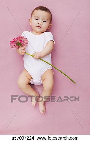 Picture - Baby girl with gerbera flowers. Fotosearch