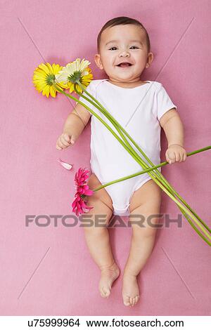 Picture - Baby girl with gerbera flowers. Fotosearch