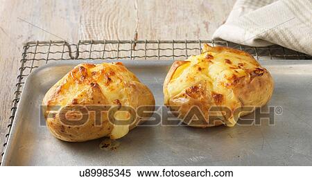 Baked potatoes with cheese on metal baking sheet View Large Photo Image Stock Photography - Baked potatoes with cheese on metal baking sheet. Fotosearch