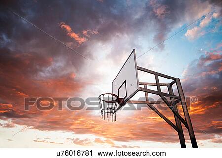Stock Image - Basketball hoop and dramatic sky. Fotosearch
