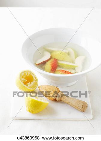 Stock Photo - Bowl of water with lemon juice to prevent vegetables from browning. Fotosearch