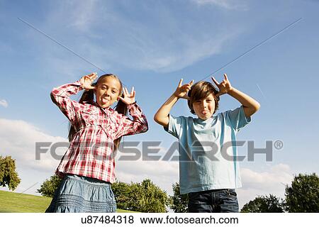 Stock Photo - Boy and girl pulling faces. Fotosearch