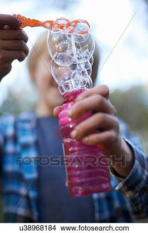 Boy holding bottle of bubbles View Large Photo Image Picture - Boy holding bottle of bubbles. Fotosearch
