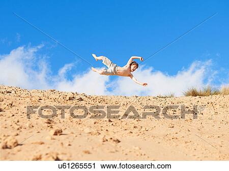 Boy jumping on beach View Large Photo Image Stock Image - Boy jumping on beach. Fotosearch