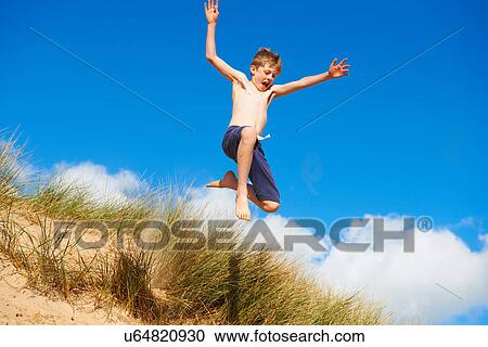 Boy jumping on beach View Large Photo Image Stock Image - Boy jumping on beach. Fotosearch