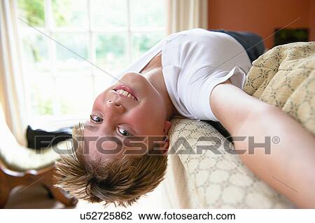 Stock Image - Boy lying on back looking at camera. Fotosearch