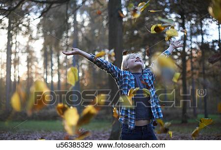 Boy throwing leaves in air View Large Photo Image Stock Photo - Boy throwing leaves in air. Fotosearch