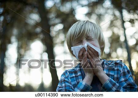 Stock Image - Boys blowing his nose. Fotosearch