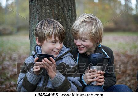 Stock Photography - Boys drinking hot drinks in forest. Fotosearch